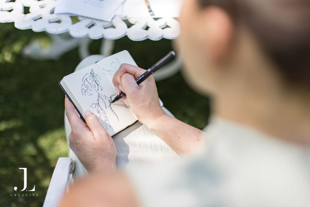Close-up of a guest drawing botanical illustrations in a sketchbook at the retreat.