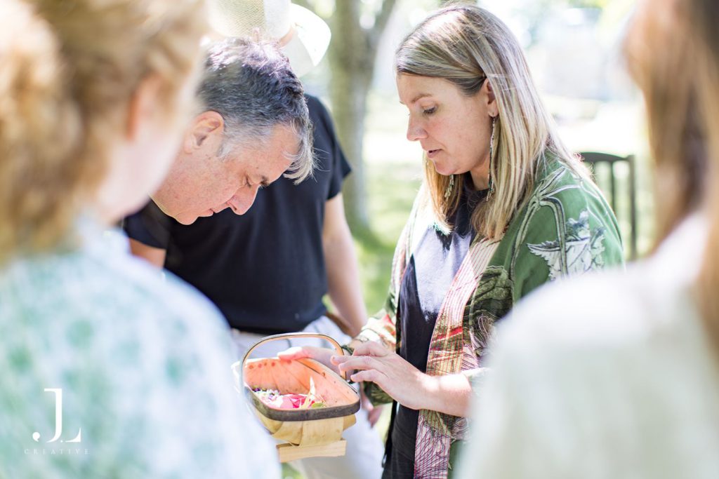 Workshop leader showing freshly picked botanicals in a wooden basket to guests