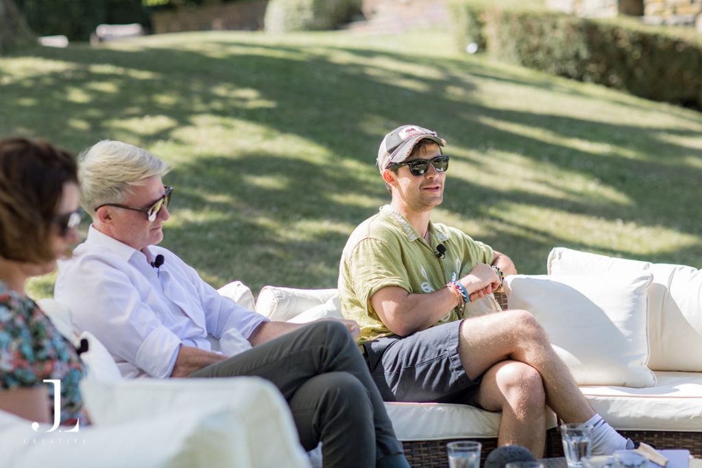 Speaker leading an outdoor panel discussion on luxury travel at Belmond retreat.