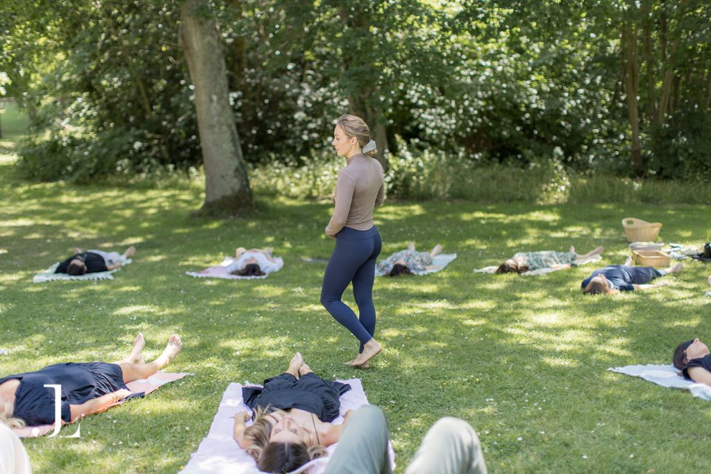Instructor leading a relaxing outdoor wellness and meditation session on the grass.