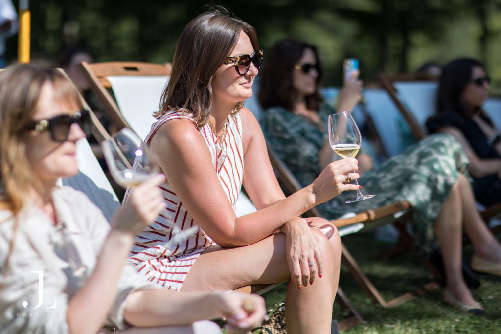 Guests relaxing in deckchairs and holding wine glasses at Belmond's Sussex retreat.