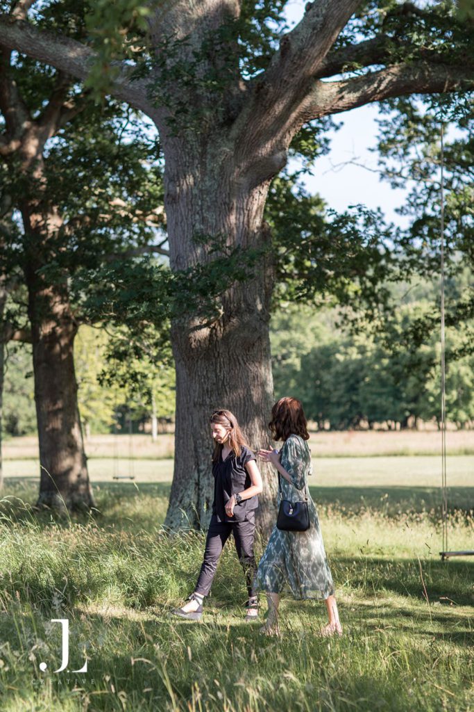 Guests strolling beneath ancient oak trees at Knepp Estate during Belmond retreat.