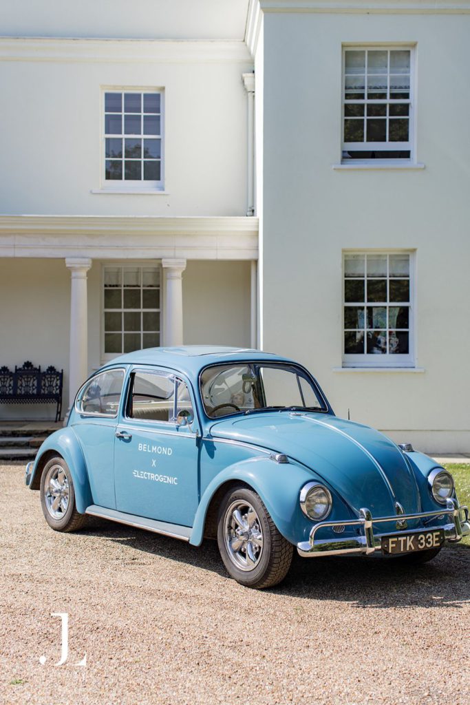 Vintage blue electric converted car parked outside the Knepp Estate house for Belmond's retreat.