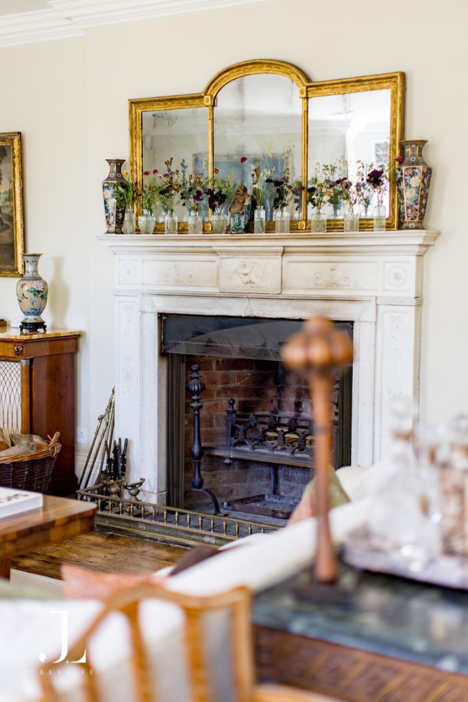Elegant fireplace display featuring wild floral styling inside Knepp Estate house.