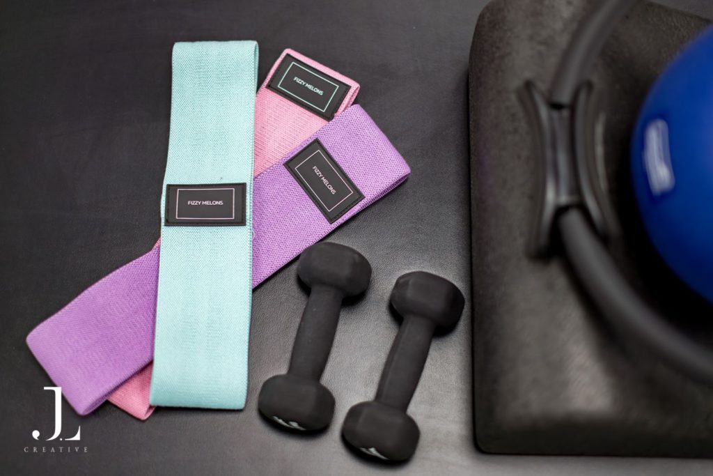 Resistance bands and dumbbells laid out for a Pilates studio branding shoot in Surrey.