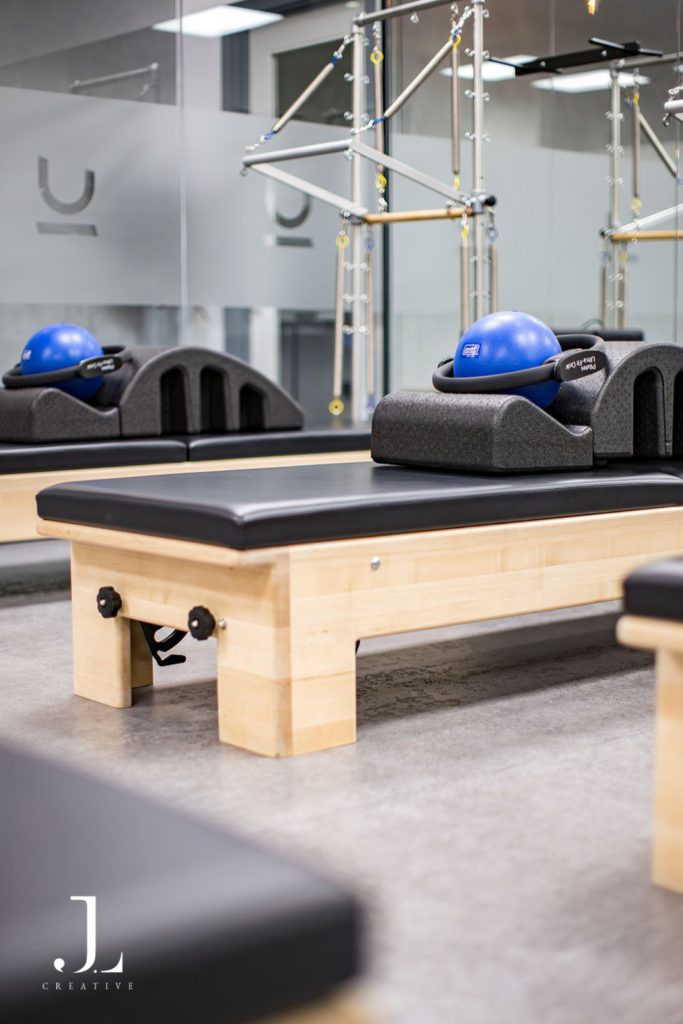 Close-up of high-end reformer equipment with blue Pilates ball in a luxury Surrey studio.