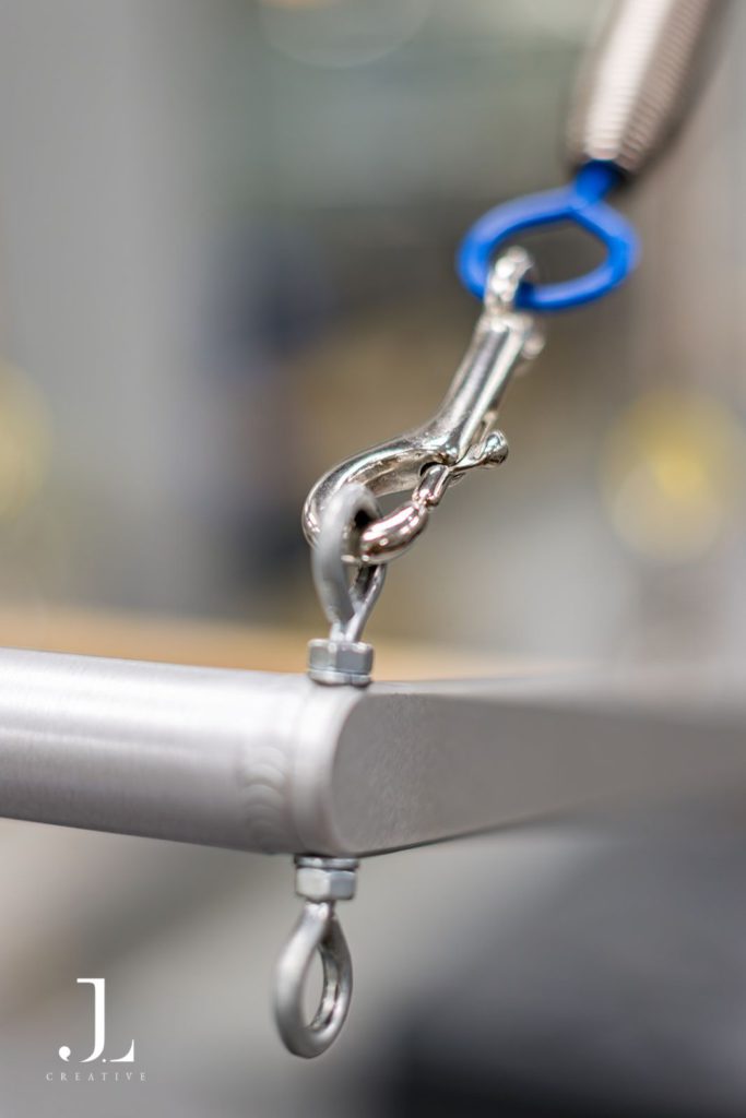 Detail macro shot of metal spring attachment on Cadillac machine at You Pilates studio.
