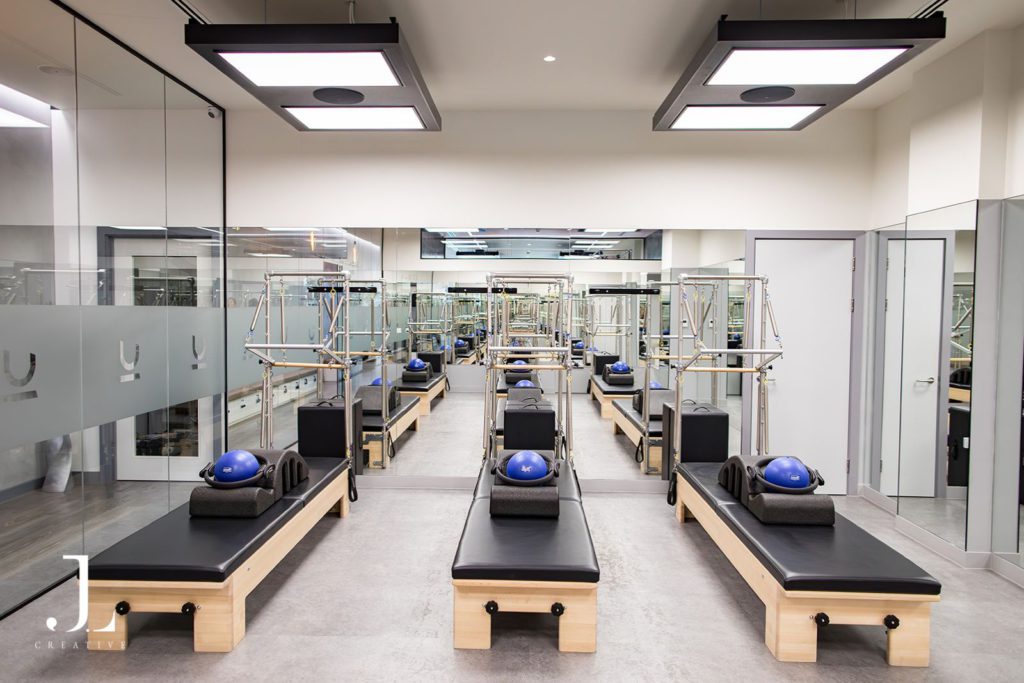 Modern interior of You Pilates studio in Cobham Surrey featuring high-end reformer equipment.
