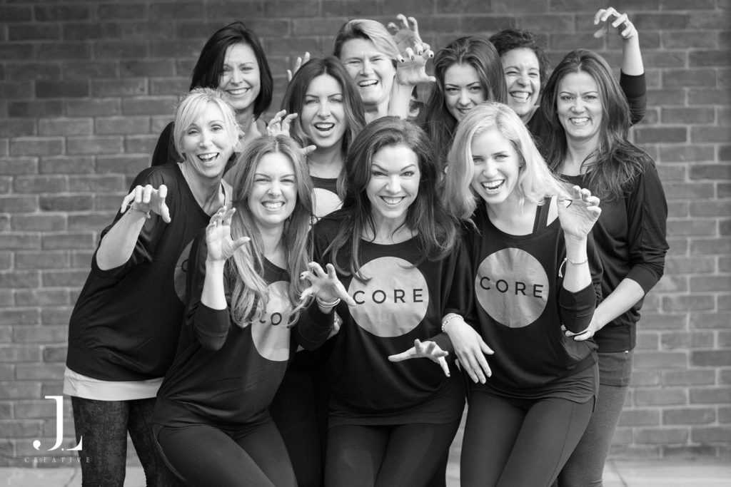 Playful group portrait of studio members during a Pilates studio photography session in Surrey.