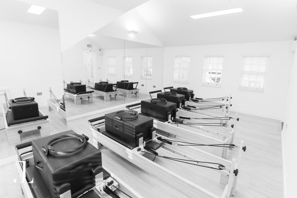 Modern reformer machines with boxes and magic circles during Pilates studio photography in Surrey.