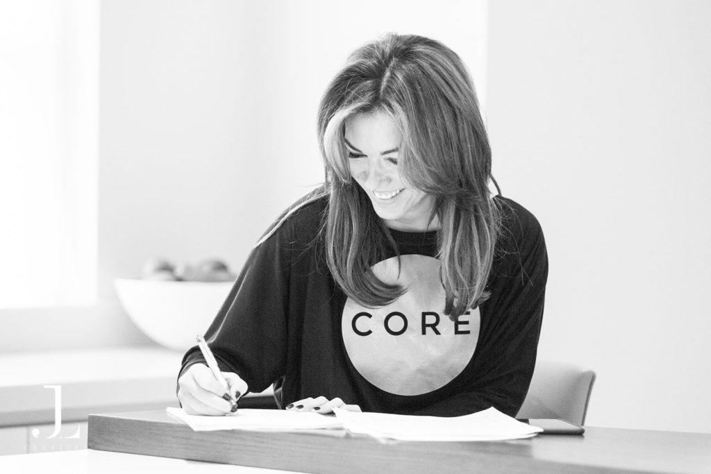 Studio owner writing notes during a branding session for Pilates studio photography in Surrey.
