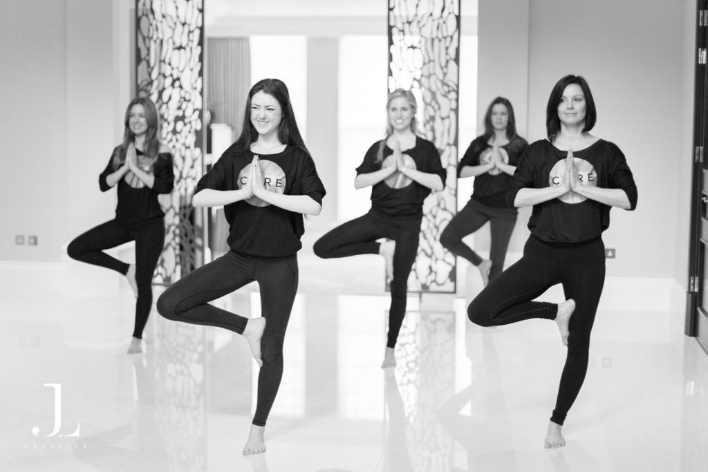 Group performing tree pose balance in a bright space during Pilates studio photography in Surrey.